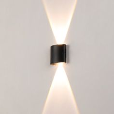 a black wall light with two white lights on it's sides and one is turned off