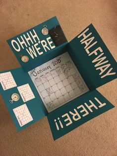 there is a calendar on the floor with words written on it and other items around it