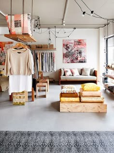 a room filled with lots of clothes and furniture