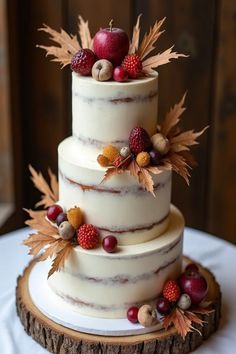 a three tiered cake with berries and leaves on top