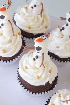 cupcakes decorated with frosting and sprinkles shaped like snowmen