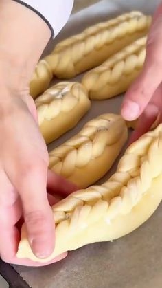 a person is holding some bread in their hand and touching it with the other hand