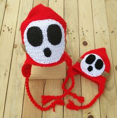 a crocheted red hat with black eyes and a white skull on the front