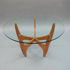 a glass and wood table with an unusual design