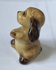 a ceramic figurine of a dog sitting on its hind legs