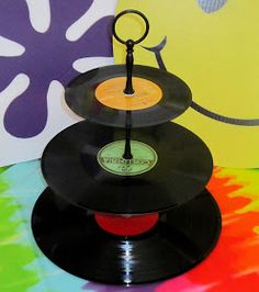 three vinyl records stacked on top of each other in front of a colorful wallpaper