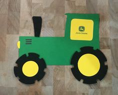 a green and yellow toy tractor sitting on top of a wooden floor