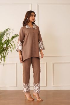 PRODUCT DETAIL: Introducing our "Blossom Brown Embroidered Co-ord Set" – a testament to grace and sophistication. This ensemble features a rich brown linen fabric adorned with exquisite white floral embroidery that adorns the collar, sleeves, and pant borders, adding a touch of timeless charm. Delicate pintex detailing on the sleeves adds a subtle yet impactful touch of intricacy to the design. Crafted with comfort in mind, the linen fabric ensures a soft and cozy feel while maintaining a formal Simple Kurta, Stylish Kurtis Design, White Floral Embroidery, Sets Outfit, Embroidered Kurti, Simple Kurta Designs, Dress Book