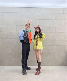 two people dressed in costumes standing next to each other with carrots on their heads