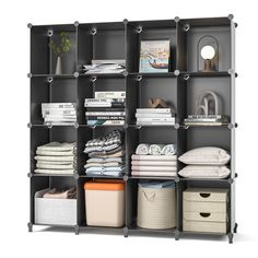 an open shelving unit with several shelves and baskets on top of it, all filled with folded clothes