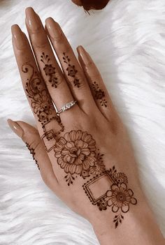 a woman's hand with henna tattoos on it