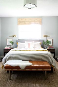 a bedroom with a bed, two nightstands and a bench