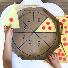 someone is making a pizza box out of cardboard with numbers on it and pieces of paper taped to the top