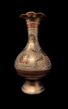 an ornate gold vase on a black background