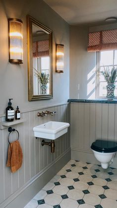 a bathroom with a toilet, sink and mirror