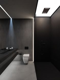 a modern bathroom with black and white walls, floor to ceiling lighting and a long counter