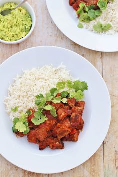 two plates with rice, meat and cilantro on them