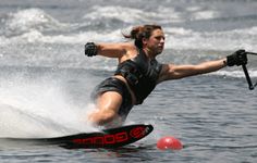 a woman water skiing in the ocean with her arms out and legs spread wide as she leans forward