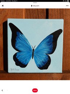 a blue butterfly painted on a wooden wall