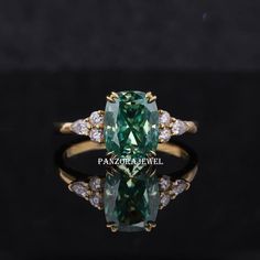 an emerald and diamond ring on a black surface