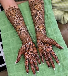 two hands with henna tattoos on them