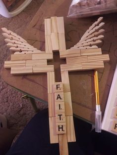 a cross made out of wooden blocks with the word faith spelled on it