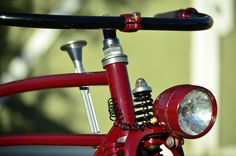 a close up of a red bike with a light on it