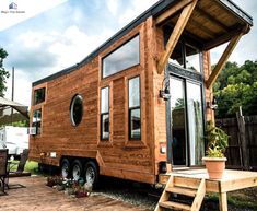 a tiny house built into the side of a wooden deck with stairs leading up to it