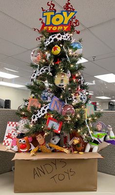 a decorated christmas tree in an office cubicle with toys on the top and below it