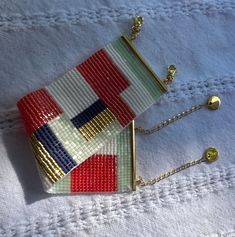 two purses sitting on top of a white cloth