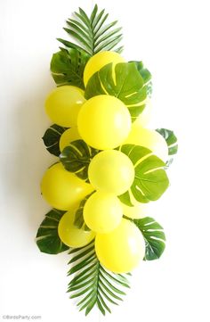 some yellow balloons and green leaves on a white background