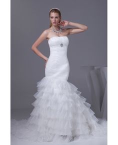 a woman in a white wedding dress posing for the camera with her hand on her head