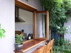 a wooden window sill sitting next to a potted plant on top of a table