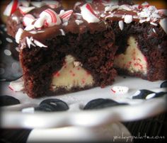 a chocolate cake with white frosting and candy canes on top is cut in half