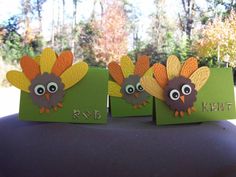 three little turkeys made out of green envelopes sitting on top of a table