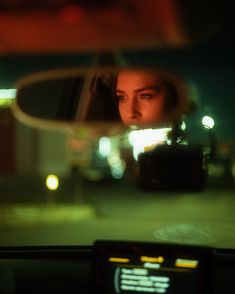 the reflection of a woman's face in a rear view mirror