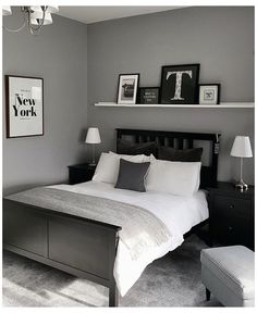 a bed room with a neatly made bed and two pictures on the wall above it