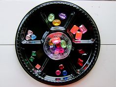 a black plate with many different colored stones on it