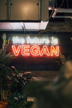 a neon sign that reads the future is vegan