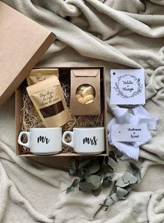 two coffee mugs in a gift box on a blanket