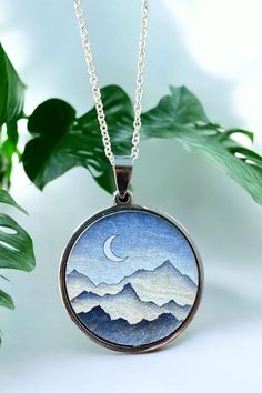 Celebrate your special milestone with our exquisite Mountain Pendant Necklace, a truly unique piece designed to capture the beauty of nature and the essence of your journey together. Perfect for a 5th anniversary gift, this handcrafted wood necklace symbolizes strength, endurance, and the peaks and valleys you've conquered as a couple. Each pendant is meticulously made from high-quality wood, showcasing the intricate details of a mountain landscape, and is paired with your choice of a gold or si Nature-inspired Sterling Silver Moon Charm Jewelry, Nature-inspired Etched Round Pendant Jewelry, Artistic Etched Jewelry For Gifts, Nature-inspired Etched Jewelry For Gifts, Nature-inspired Etched Jewelry Gift, Nature-inspired Round Etched Jewelry, Nature-inspired Necklace With Round Pendant For Anniversary, Nature-inspired Moon Charm Pendant Necklace, Nature-inspired Round Pendant Jewelry With Moon Charm