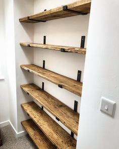 the shelves are made out of wood and have black metal brackets on each shelf,