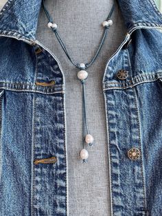 Denim stained genuine leather and pearl necklace and earring set.  There are 10 freshwater cultured pearls on this necklace.  There are 5 freshwater cultured pearls on each earring. Every  creamy white pearl is unique in size, shape, luster, iridescence and character. The pearls in the neck area are mostly 6-7mm and  have been barrel knotted and secured to the leather.  The large baroque center pearl is 14mm. It has been wrapped and secured in triple barrel knots.  The tassel hanging from the baroque pearl has two strands of leather each having a teardrop pearl (11-12mm) that dangles at the end.  I love this denim colored leather. I pictured it with the denim jacket to emphasize that it would look amazing  with western wear, however; this necklace  set would be perfect with any coastal or Denim And Pearls, Pearl Necklace And Earring Set, Leather Pearl Necklace, Pearl Leather, Necklace And Earring Set, Freshwater Cultured Pearls, Colored Leather