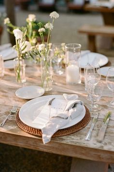 the table is set with white plates and silverware