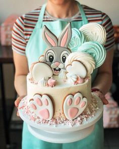 a person holding a cake decorated like a rabbit