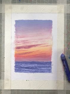 a watercolor painting of a sunset over the ocean with a blue pen on it