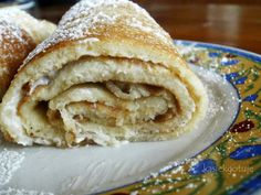 two pastries sitting on top of a plate covered in powdered sugar