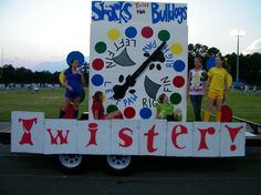 some people are standing on the back of a truck that is decorated like a clock