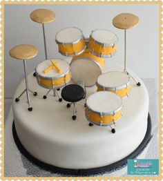 a white cake with yellow drum set on top