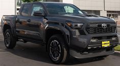 a gray toyota pickup truck parked in front of a building